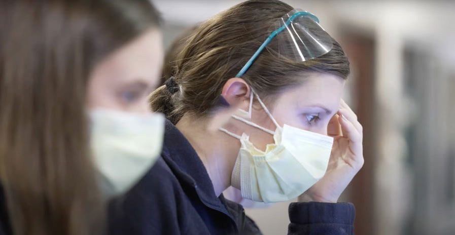 Nurse wearing a mask looking down